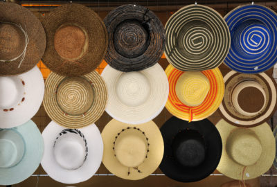 Hats collection hanging on souvenir shop, street market selling hats, background