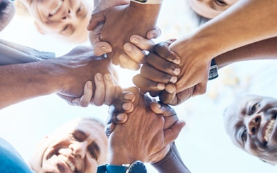 group of people holding hands and smiling